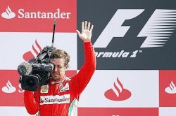 Ferrari Formula One driver Alonso of Spain waves as he films supporters from the podium as he celebrates his third place in the Italian F1 Grand Prix at the Monza circuit